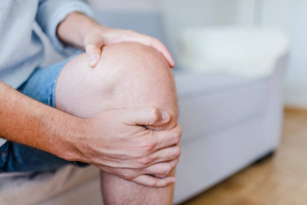 istock Man suffering from knee pain at home, closeup 987398810