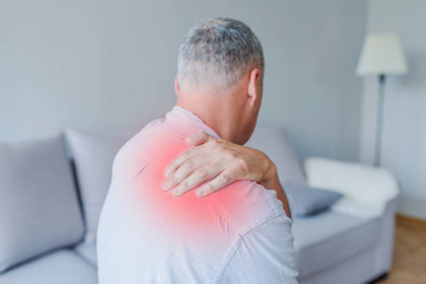 istock Man grimaces at the pain in his shoulder 987399078