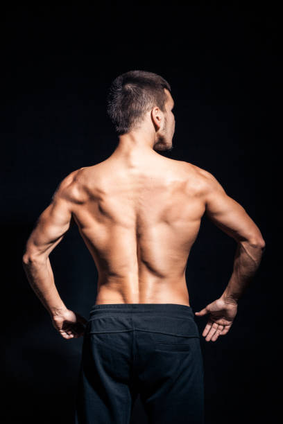 istock young handsome man with perfect torso on black background; 987403500