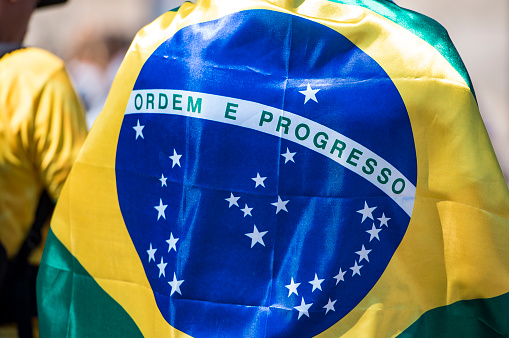 Soccer fan national team of Brazil celebrating goal in front of brazilian flag on map