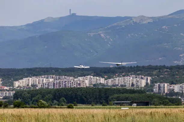 Motorless sailplane towed by another aircraft over a city