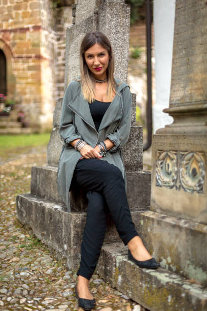 istock Woman sitting near old stone wall 987421612
