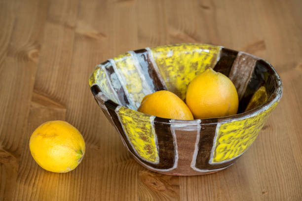 istock Composition of bright ceramic bowl and yellow lemons. 987428018
