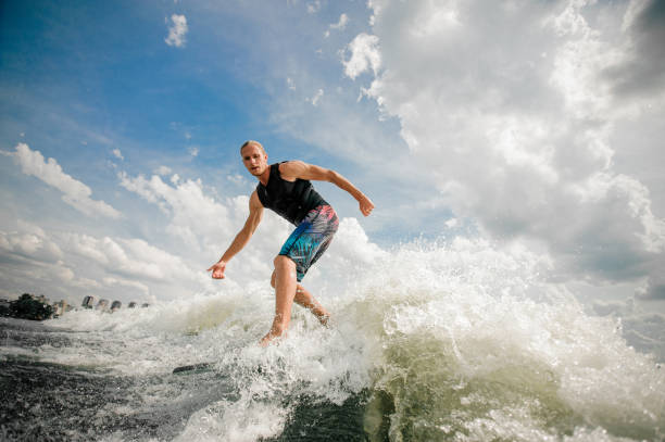 istock Young attractive man riding on the wakeboard 987442360