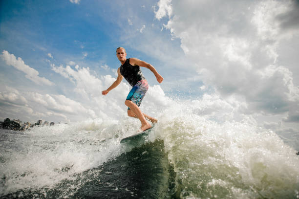 istock Young attractive active man riding on the wakeboard 987443790