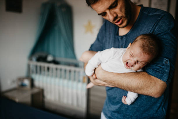 papa, tenant le bébé qui pleure dans le portage de coliques - pleurer photos et images de collection