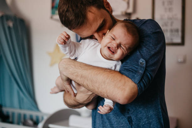 istock Dad embracing crying baby 987451460