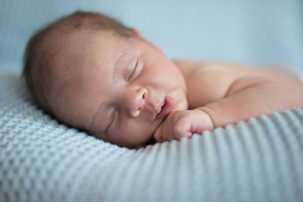 istock Sleeping newborn baby on blue blanket 987451668
