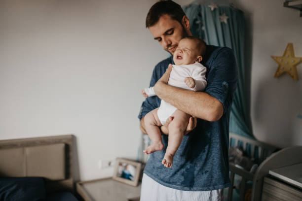 istock Father holding crying colicky baby 987451706