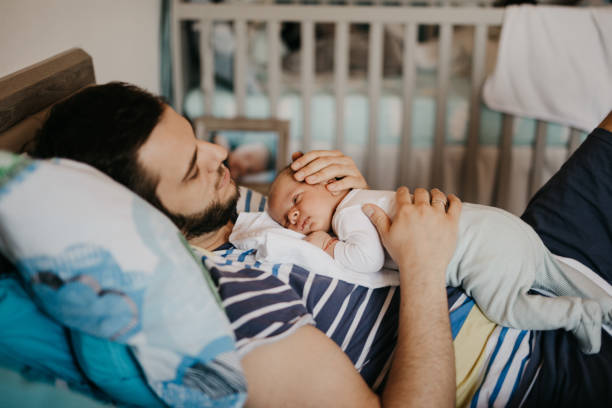 istock Father and baby son sleeping in bedroom 987452736