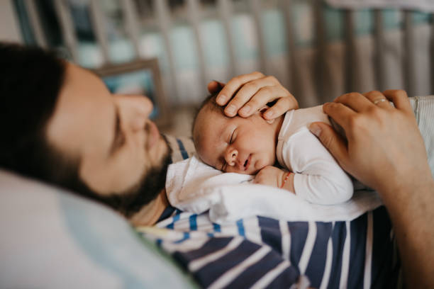 istock Father and baby son sleeping in bedroom 987452798