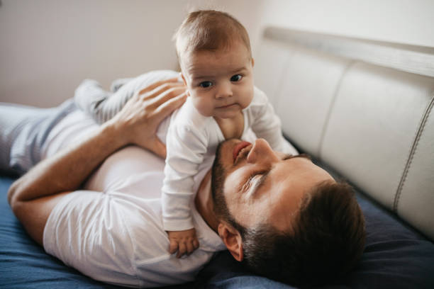 istock Father playing in bed with his little baby boy 987461820