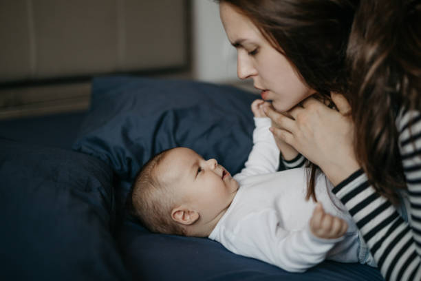 istock Mother playing with her newborn son in bed 987462144