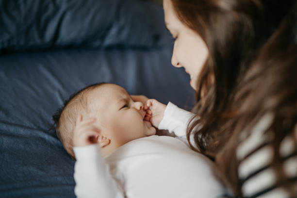 istock Mother playing with her newborn son in bed 987462552