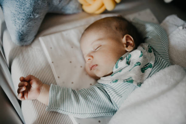 piccolo bambino carino che dorme in nursery cot - baby sleeping bedding teddy bear foto e immagini stock