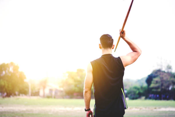 спортсмен разогрева и практикующих метание копья во дворе - javelin sport photography outdoors стоковые фото и изображения