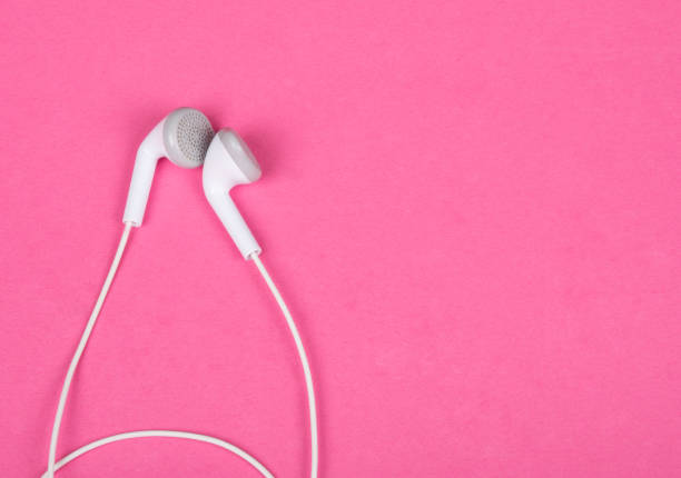 istock White earbud headphones isolated on a pink background 987496000