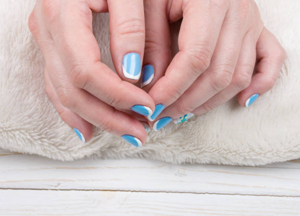 istock Female hands with manicured nails on a white towel 987500360