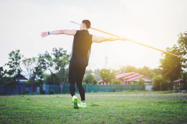 istock sportsman warming up and practicing javelin throw in yard 987505210