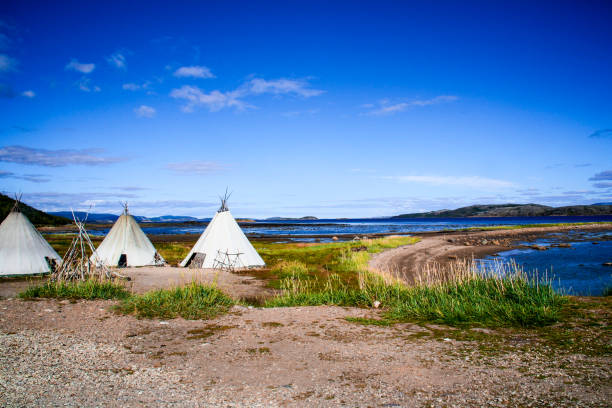 три лавву юрты сидят рядом с озером в районе альта в регионе финнмарк на севере норвегии и лапландии в летний день - lapp стоковые фото и изображения