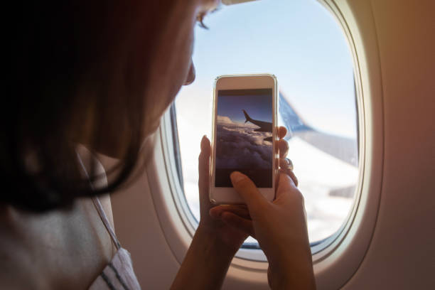 istock Young woman taking a picture on an airplane 987539468