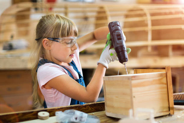 istock Young girl doing woodwork in a workshop 987549994