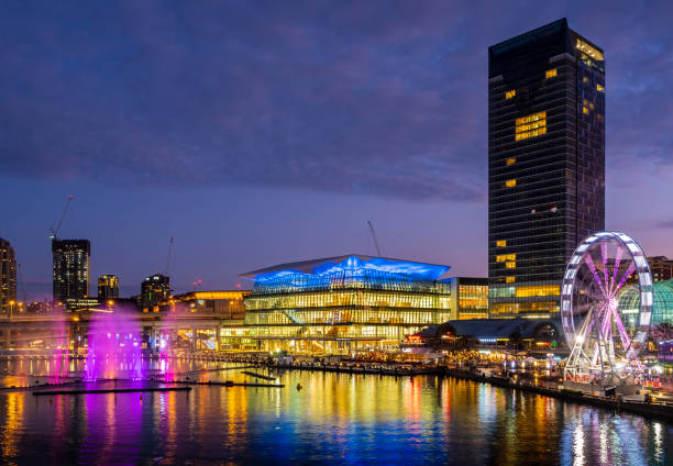 Sydney, Australia - May 22, 2017: Sydney skyline in the Central Business District (CBD) at sunset. Image features the luxurious Sofitel Hotel (tall) and the Convention Center. Fountain on water.