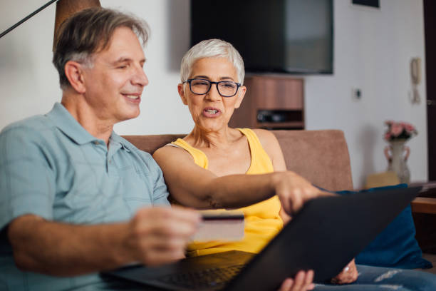 istock Senior couple using laptop while shopping online 987558130