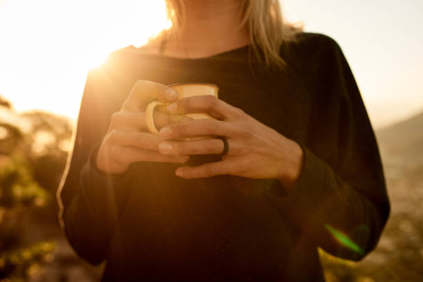 Cropped shot of an unrecognizable young woman taking a coffee break during her mountain hike