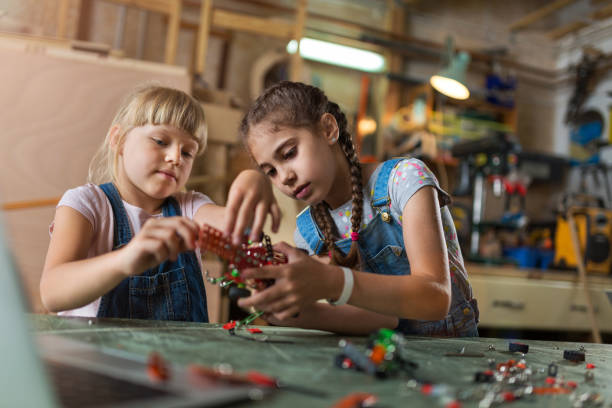 istock Small girls building toy construction machine 987568850