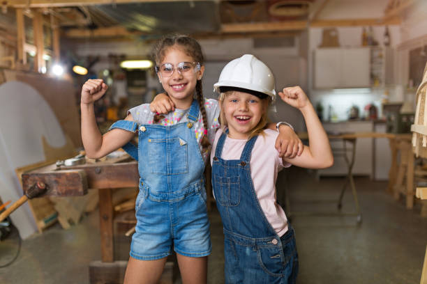 Kids Wood Crafts Two young girls doing woodwork in a workshop girl with a hammer stock pictures, royalty-free photos & images