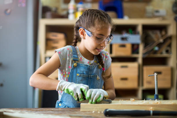 istock Young girl doing woodwork in a workshop 987571702