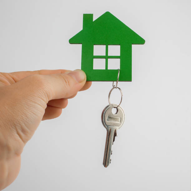 istock hand with key and house shape on white 987571878