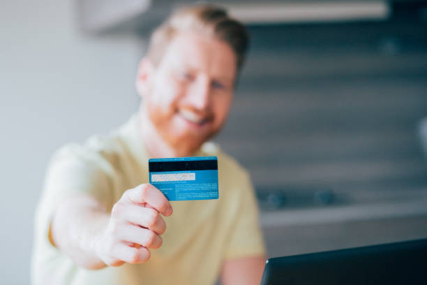 istock Smiling man with a credit card 987573442
