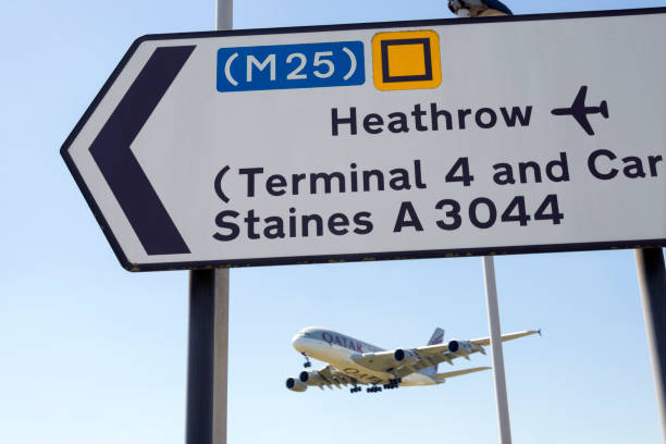 Airplane landing at Heathrow Airport, London, UK Heathrow, UK - June 27, 2018: Landing Qatar Airways airplane above a street sign for Heathrow airport. heathrow airport stock pictures, royalty-free photos & images