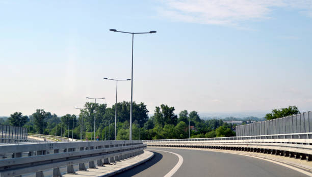 dobre à esquerda sobre o novo, moderno, rodovia de múltiplas pistas, na montanha - multiple lane highway highway car field - fotografias e filmes do acervo