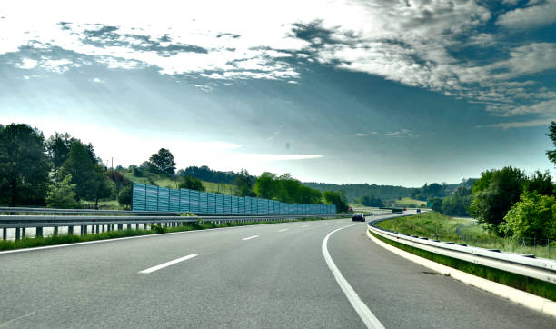 istock Bend to the right on the new, modern, multiple lane highway with a protective fence 987577748