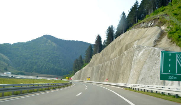 bend to the left on the new, modern, multiple lane highway, in the mountain - multiple lane highway highway car field imagens e fotografias de stock