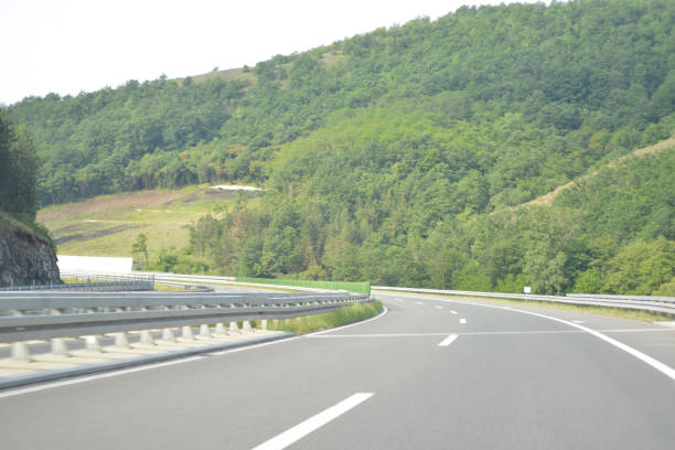 bend to the left on the new, modern, multiple lane highway, in the mountain - multiple lane highway highway car field imagens e fotografias de stock