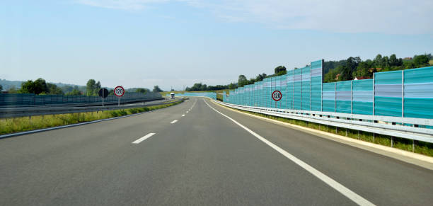 bend to the left on the new, modern, multiple lane highway, with a protective fence - multiple lane highway highway car field imagens e fotografias de stock