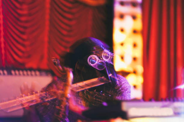 istock Man with mask playing flute on stage 987578742
