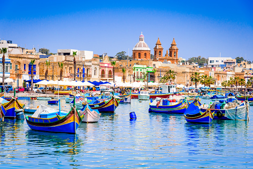 Malta. Traditional eyed colorful boats Luzzu in the Harbor of fishing village Marsaxlokk, Mediterranean Sea.