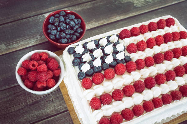 Multi-generation family on picnic in back yard eating hot dog and celebrating 4th of July - Independence Day. Focus on parents embracing.