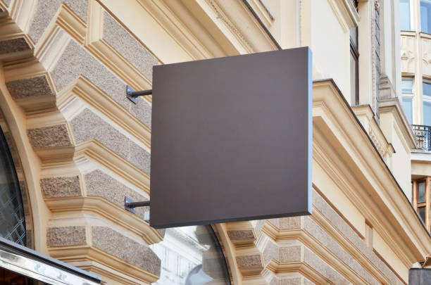 istock Simple store signage mockup. Square shape. Modern city facade in the background 987605048