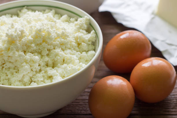istock fresh rustic cottage cheese and eggs on wooden background, baking ingredients 987606540