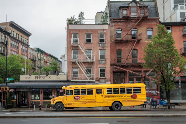 New York City, United States - 7 Sept 2023: Yellow School Bus on Manhattan street, schoolbus truck on city road, Chinatown. Children education, transportation in USA. American school shuttle. People.