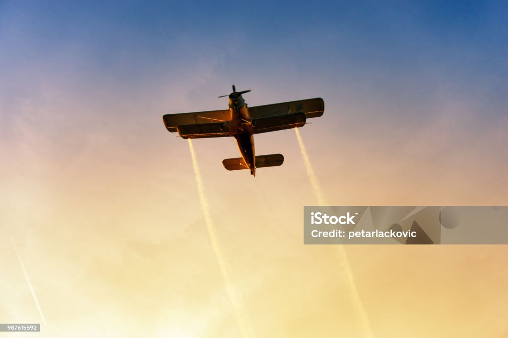 Biplane flying in the vibrant sunset Airshow Stock Photo