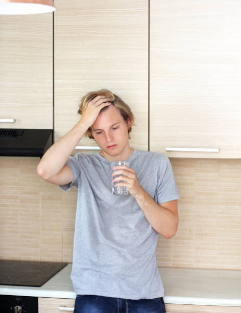 istock Teenager depressed  standing in the kitchen 987622414