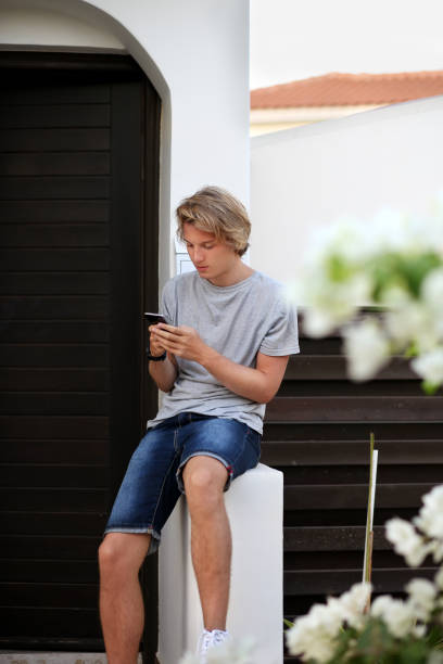 istock Teenage boy typing text message.Using smart phone. 987622450