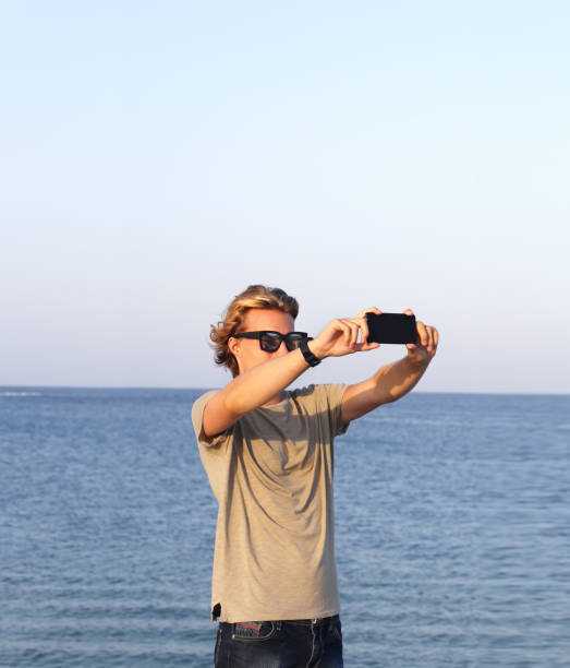 istock Teenage boy using smart phone.Selfie 987623040